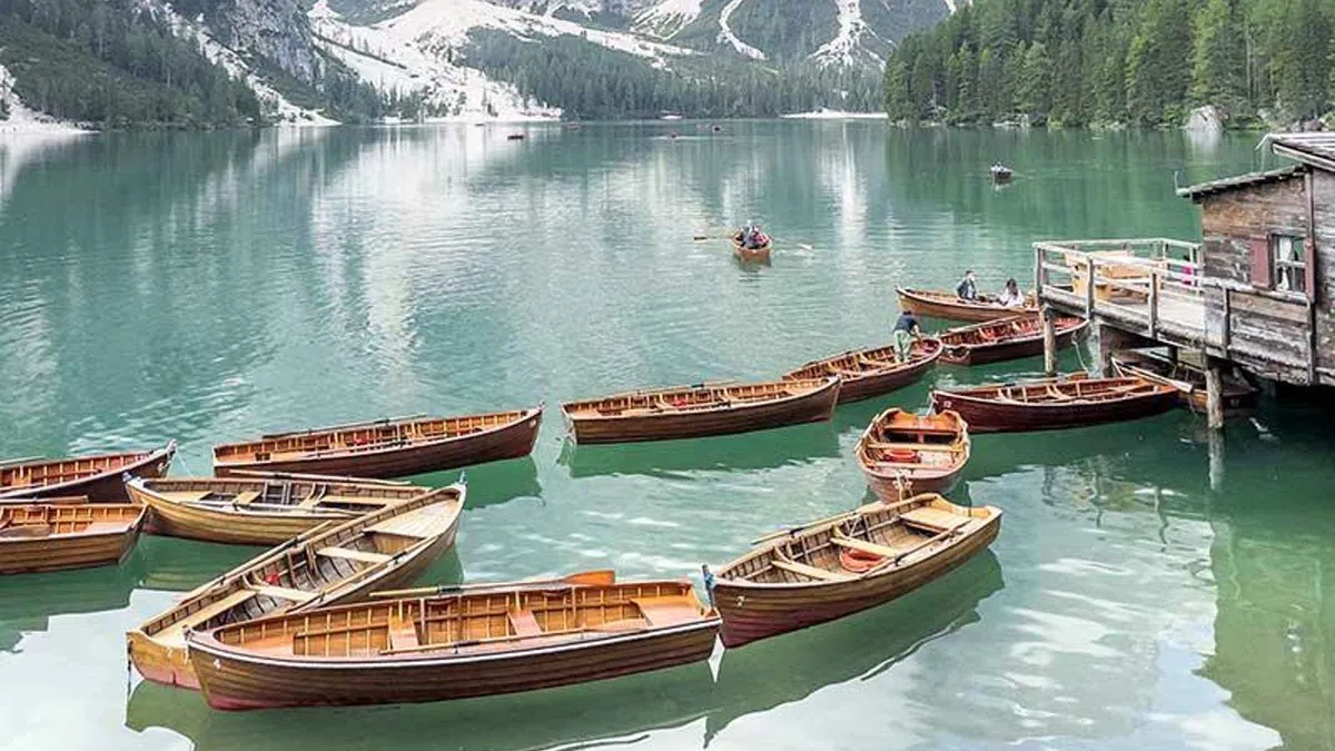 Wooden rowing boats moored side by side at the boathouse on Lake Braies