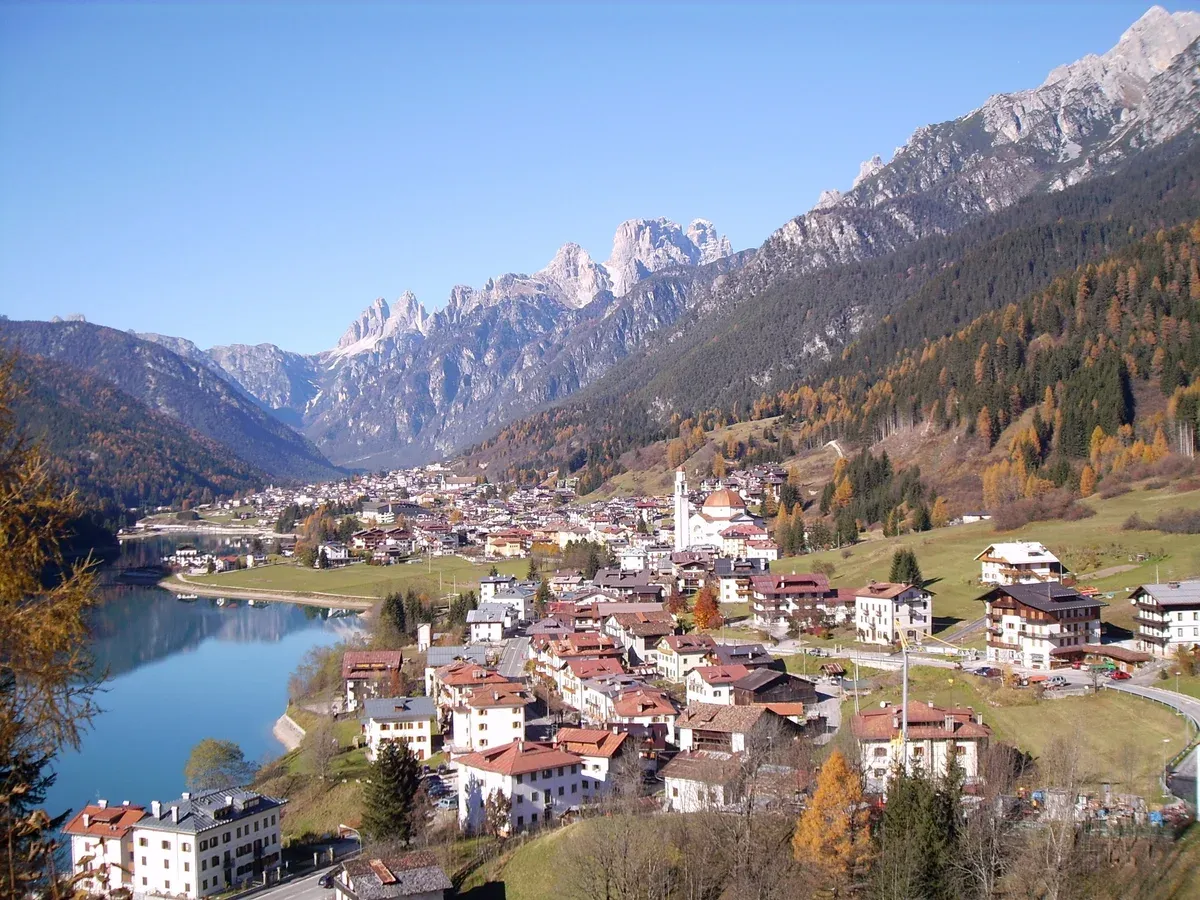 The town of Auronzo di Cadore above its reservoir lake with Dolomite peaks behind