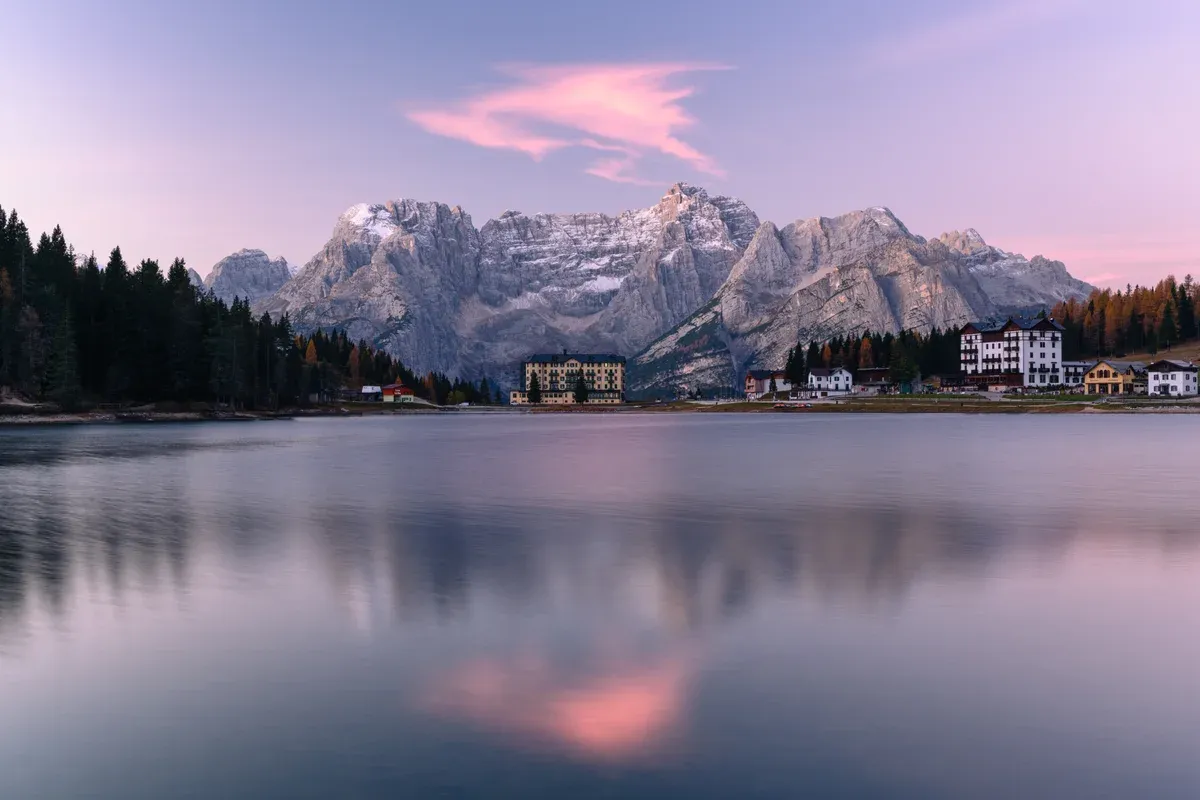 Pink clouds at sunrise over Lake Misurina with the Sorapiss massif reflected in the water