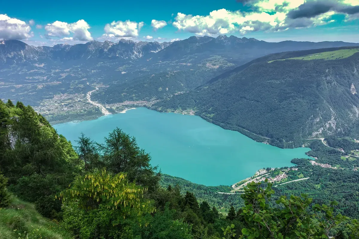 Turquoise Lake Santa Croce in the Alpago valley seen from a hillside above