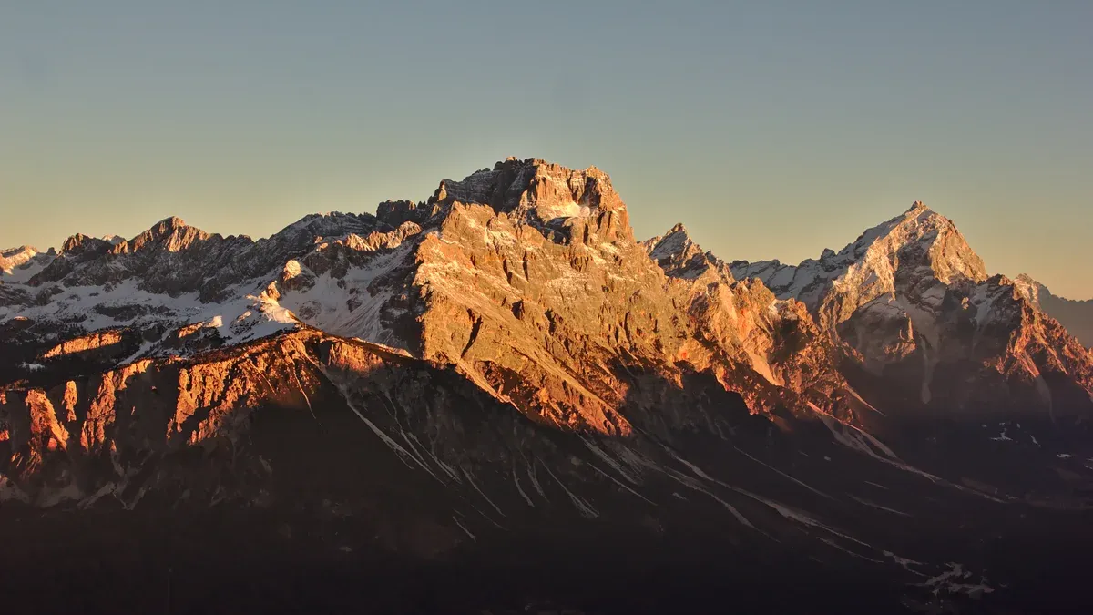 The Sorapiss and Antelao massifs above the Cortina valley at sunset, rock faces glowing orange